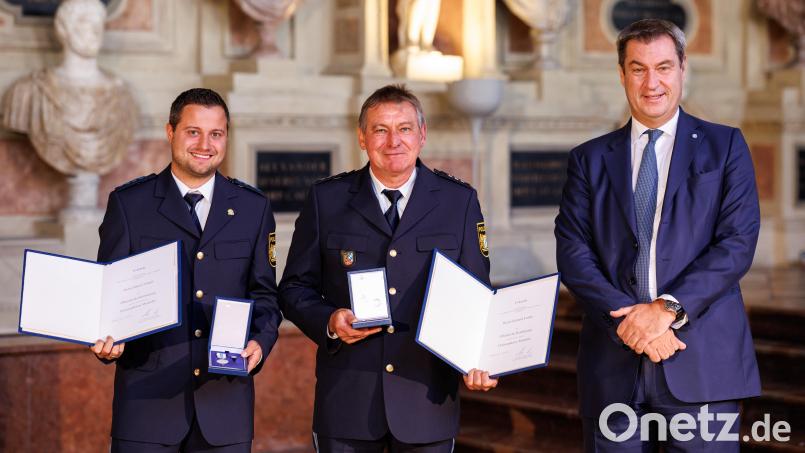 Ministerpräsident Markus Söder präsentiert sich hier zusammen mit den beiden Lebensrettern Gerhard Fröller (Mitte) und Daniel Tröger (links) , denen er im Antiquarium der Residenz in München die Christophorus-Medaille verliehen hat. Bild: Matthias Balk/Bayerische Staatskanzlei