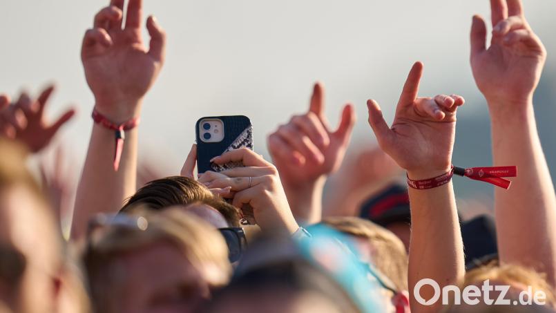 Eine Zuschauerin benutzt ihr Smartphone beim Auftritt des Rappers Aligatoah vor der Hauptbühne des Open-Air-Rockfestivals &quot;Rock am Ring&quot;. Symbolbild: Thomas Frey/dpa
