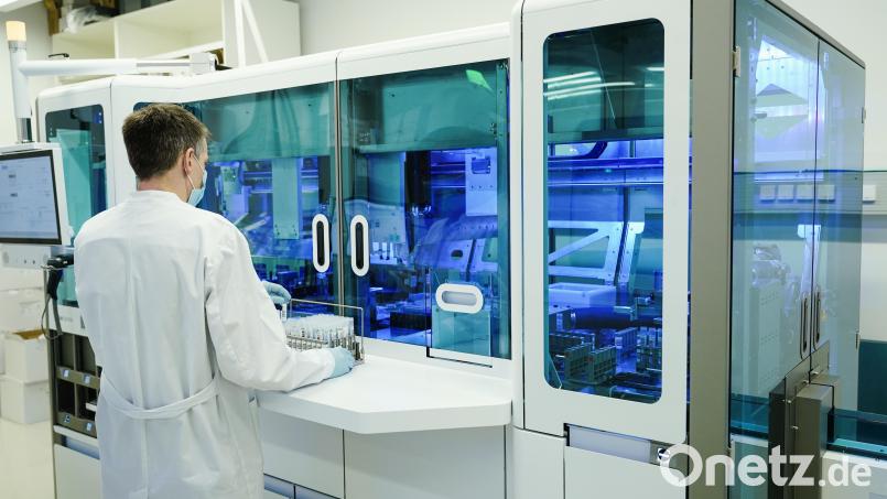 Ein Mitarbeiter hält in einem Coronatest-Labor PCR-Teströhrchen in den Händen. Symbolbild: Uwe Anspach/dpa