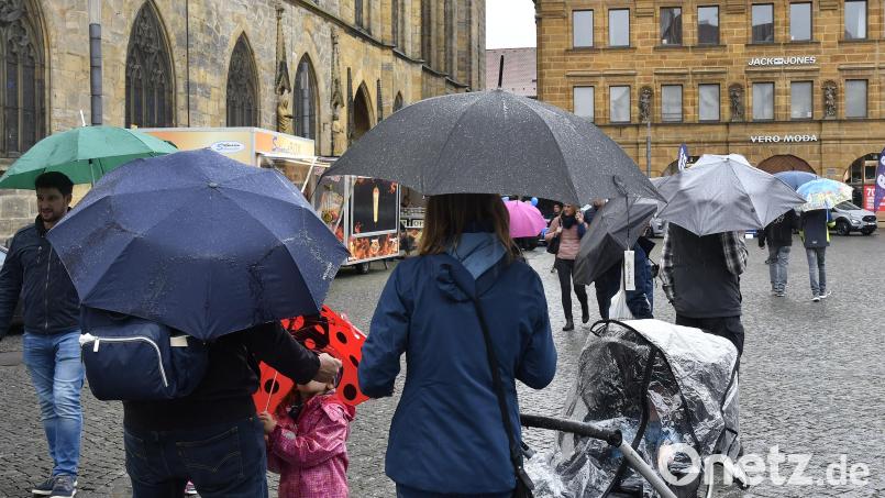 Ohne Regenschutz geht zurzeit in Amberg gar nichts. Der verkaufsoffene Sonntag lockt bisher nur wenige Menschen in die Stadt. Bild: Petra Hartl