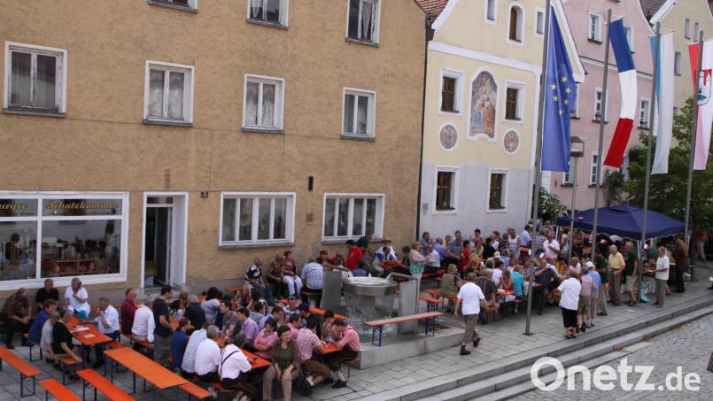 Zum Brunnenfest am Castillon-Brunnen in der Nabburger Altstadt unter den Flaggen der Europäischen Union und den der Partnerstädte kommen Menschen beider Länder zusammen. Bild: mis