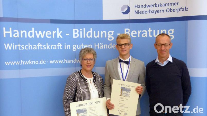 Jakob Völkl (Mitte) gewinnt in der Berufssparte „Bestattungsfachkraft“ den Leistungswettbewerb des Deutschen Handwerks auf Kammerebene für den Bezirk Niederbayern-Oberpfalz. Dafür erhalten er und sein Ausbildungsbetrieb, die Weidener Firma Bestattung Bauer, eine Auszeichnung. Die Geschäftsführer Martina Fuhrmann (links) und Wolfgang Dobler (rechts) nehmen diese entgegen. Bild:  Dietmar Völkl/exb