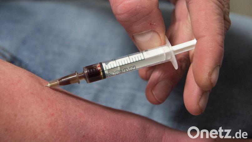 Ein Drogensüchtiger spritzt sich Heroin in den Unterarm. In Amberg wird derzeit ein Fall verhandelt, bei dem nach dem Tod einer Frau durch eine Überdosis Heroin der Verdacht auf unterlassene Hilfeleistung im Raum steht. Symbolbild: Boris Roessler/dpa
