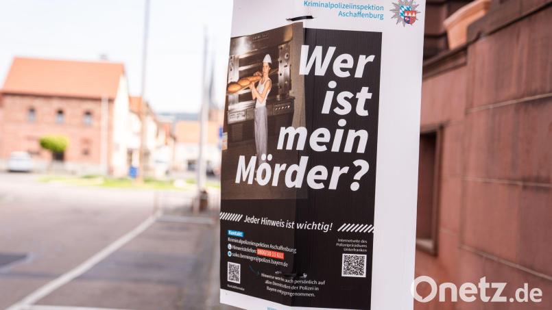 Ein Plakat der Kriminalpolizeiinspektion Aschaffenburg mit der Aufschrift „Wer ist mein Mörder?“, das den ermordeten Klaus Berninger zeigt, hängt in der Innenstadt. Bild: Nicolas Armer/dpa/Archivbild