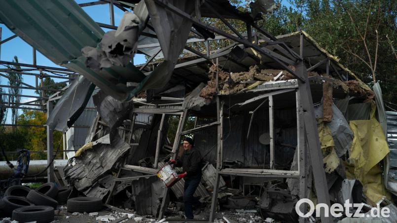 Nach dem russischen Raketenangriff löscht ein Mann in Saporischschja die Überreste eines Feuers in einer zerstörten Autowerkstatt. Bild: Leo Correa/AP/dpa