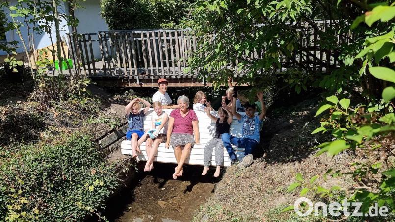 Eine sogenannte &quot;Doppelsitzbank&quot; nimmt ihren Platz über den Bach ein, damit Sitzende im Sommer ihre Füße im Wasser baumeln lassen können. Bild: Ewald Zenger