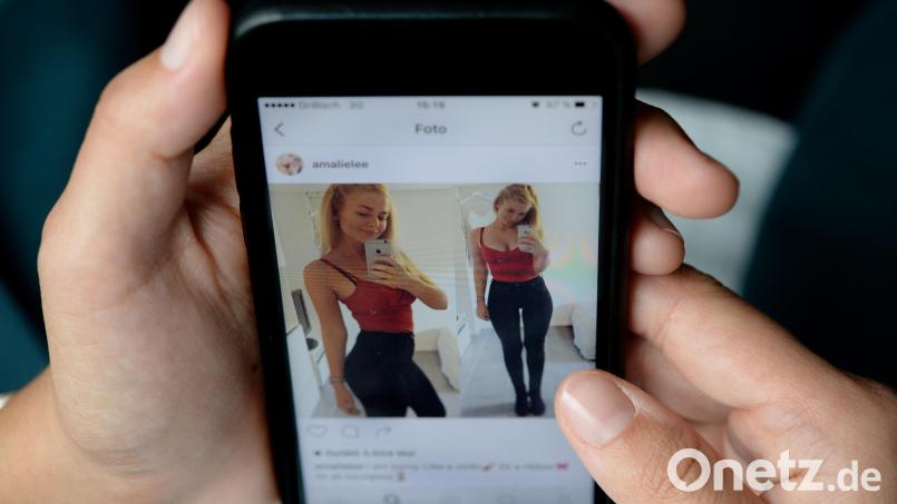 Eine junge Frau schaut sich das Instagram-Profil von Nutzerin Amalie Lee auf dem Display eines Smartphones an. Auf Instagram dokumentiert Lee, die an einer Essstörung leidet, ihren Weg zurück - ihre Heilung. Symbolbild: Monika Skolimowska/dpa