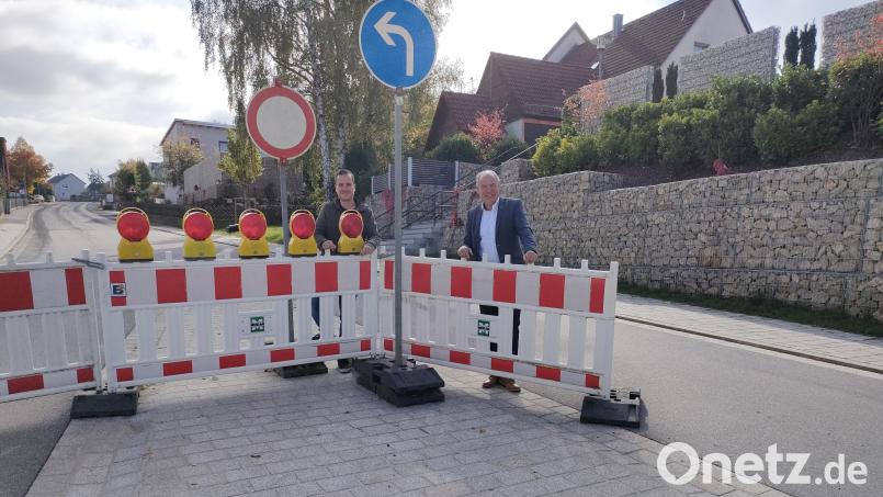 Bürgermeister Roland Strehl (rechts) mit Stephan Schiedermeier (links) vom Bauamt geben den Butzenweg offiziell für den Verkehr frei. Bild: Anja Jäger/exb