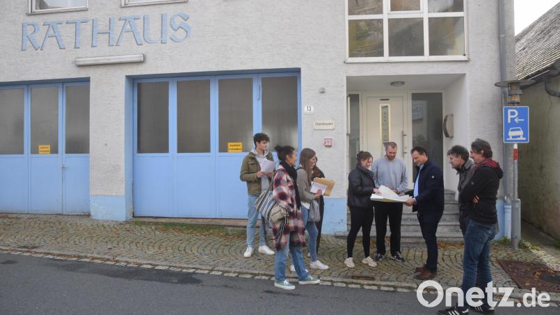 Die Professoren Andreas Müsseler und Markus Emde schauen in die Pläne des alten Rathauses, die Bürgermeister Anton Kappl (von rechts) den Studenten zeigt – ein spannendes Objekt für die jungen Leute. Bild: fz