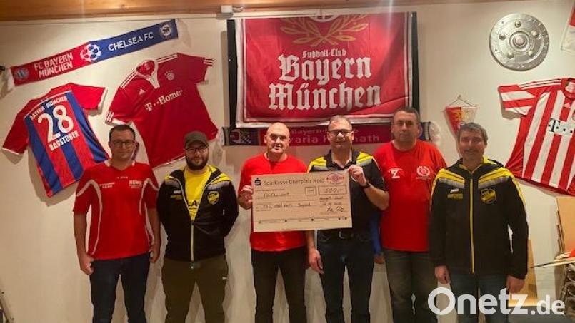 Stefan Dötsch, Holger Schmidt und Stefan Gilch (von rechts, jeweils in schwarz-gelben Trainingsjacken) freuten sich über den Spendenscheck des FC-Bayern-Fanclubs, den Johann Kreuzer, Vorsitzender Rainer Kische und Klaus Fiebig (von links in roten Shirts) übergaben. Bild: jzk