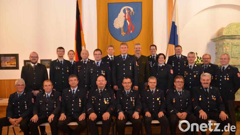 Alle Feuerwehrmänner, die sich seit 40 Jahren aktiv in den Feuerwehren der Großgemeinde engagieren, durften in der erste Reihe Platz nehmen. Landrat Andreas Meier (hinten links) und Bürgermeister Andreas Wutzlhofer (hinten Mitte) dankten für den Rund-um-die-Uhr-Einsatz bei den Feuerwehren. Bild: dob