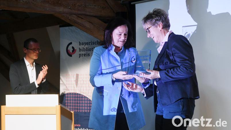 Ute Eiling-Hütig (links), 1. Vorsitzende des Bayerischen Bibliotheksverbandes, übergibt am Mittwoch den mit 10.000 Euro dotierten Hauptpreis an Sabine Guhl (rechts), Leiterin der Regionalbibliothek in Weiden. Bild: Gabi Schönberger