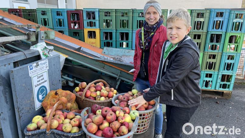 Mutter und Sohn hieven gemeinsam die schweren Körbe auf die Waage - jetzt ist die Anlieferung von Obst für die Saftpresse zu Ende. Bild: ige