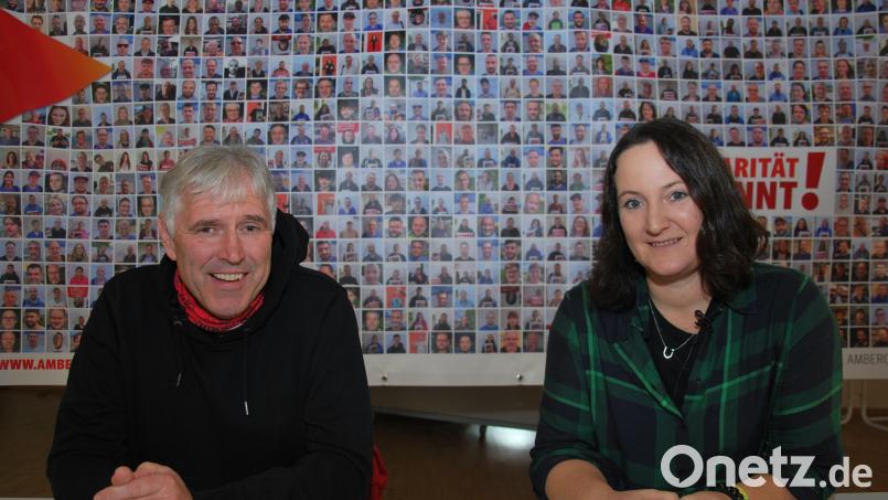 Horst Ott und Sabrina Feige vor einer Foto-Collage mit Bildern von Beschäftigten in der Metall- und Elektrobranche, um deren Einkommen es bei der Tarifrunde geht. Bild: gsp