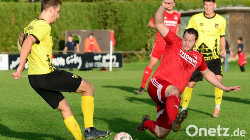 Pfreimds Spielertrainer Bastian Lobinger (rotes Trikot) haut sich voll rein. Aich gegen den ASV Burglengenfeld gab es für die SpVgg keine Punkte. Bild: ham