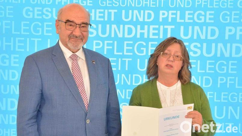 Peter Bauer (links), der Patienten- und Pflegebeauftragte der Bayerischen Staatsregierung, zeichnet Cornelia Lochner aus Amberg aus. Bild: StmGP/exb
