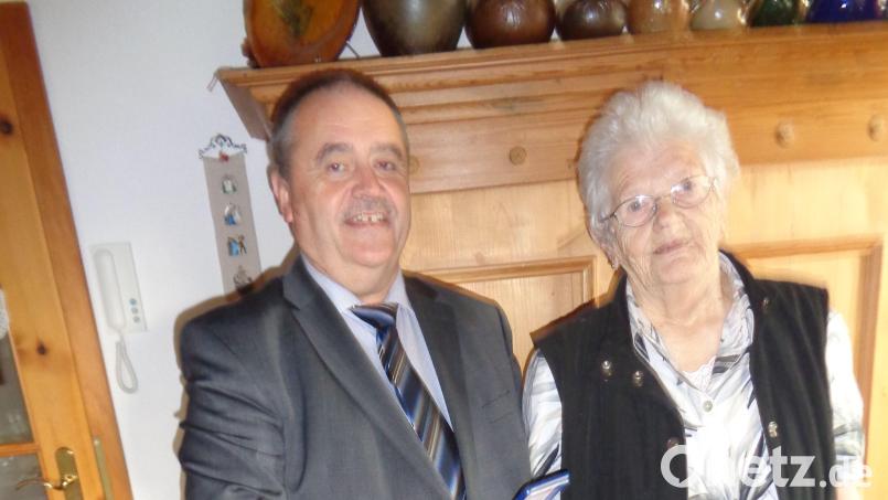 Bürgermeister Peter Dotzler überreicht Barbara Schöpf anlässlich ihres 90. Geburtstags die Landkreismedaille in Bronze. Bild: dpe