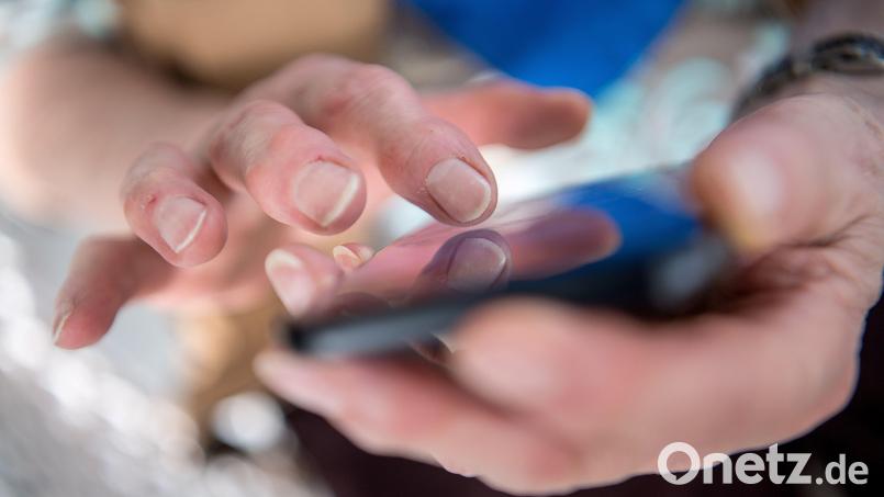 Eine Seniorin tippt auf ihrem Smartphone. Die Amberger Polizei warnt vor sogenannten Enkeltrick-Betrügereien. Bild: Sebastian Gollnow/dpa