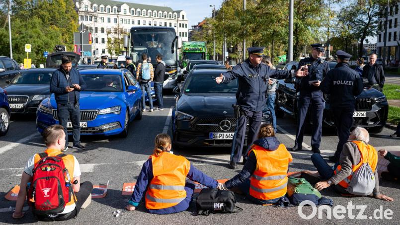 Klimaaktivisten haben sich am Karlsplatz in der Münchner Innenstadt auf die Fahrbahn geklebt und blockieren die Straße. Bild: Lennart Preiss