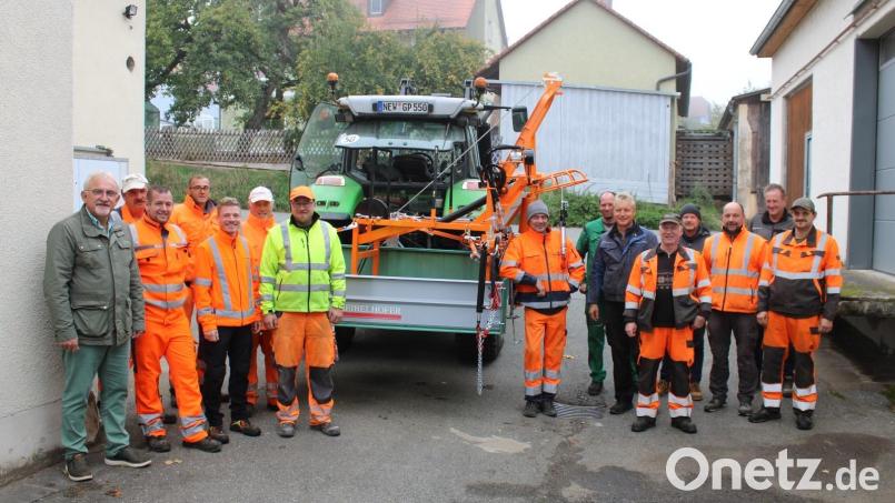 Bürgermeister Rudolf Schopper und die Bauhofmitarbeiter aus den fünf Gemeinden nehmen den neuen gemeinsam beschafften Sinkkastenheber in Empfang. Bild: exb/Gemeinde Püchersreuth