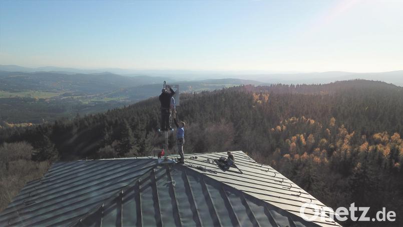 Auf dem Dach des Böhmerwaldturms wird die neue Fahne montiert. Bild: Hermann Markgraf/exb
