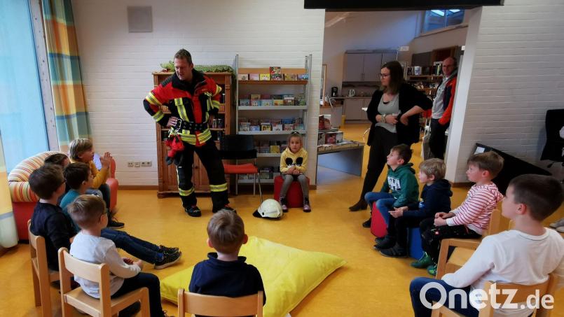 Feuerwehrmann Jürgen Merold erzählt den Kindern einiges über seine Arbeit und liest spannende Geschichten vor. Im Namen der Eltern und Kinder dankt Büchereileiterin Melissa Brenner. Bild: gz