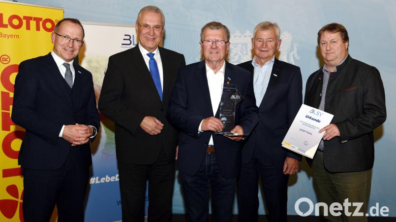 Josef Pohl (Mitte) bekommt den Titel &quot;Bezirksehrenamtlicher des Jahres&quot; verliehen. Dazu gratuliert unter anderem Innenminister Joachim Herrmann (Zweiter von links). Bild: Ruth Plössel/exb