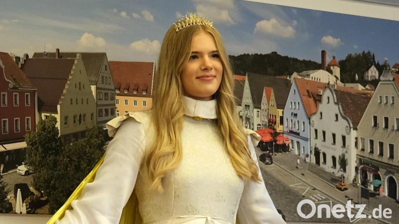 Das Schwandorfer Christkind Corinna Hirsch vor einem Bild mit der Stadtsilhouette. Bild: Hirsch
