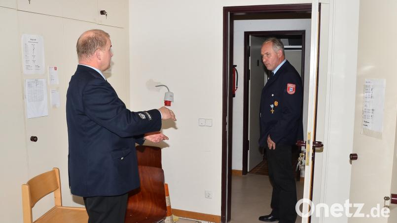 Mit den Händen zeigt Kommandant Markus Schwarz seinem Reichenauer Amtskollegen Josef Spitzner an Ort und Stelle den entstandenen Abstand von bis zu 15 Zentimeter zwischen Mauern und Betondecke im Obergeschoss des Feuerwehrhauses. Bild: fjo