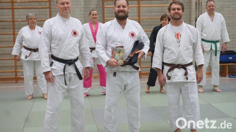 Tobias Schwendner freut sich über die bestandene Prüfung zum Schwarzgurt. Der 1. Vorsitzende der Ju-Jutsu-Abteilung „Team Bushido“ , Erwin Bauer (links), und der 2. Vorsitzende des Hauptvereins 1. Judoclub Weiden, Christian Kett (rechts), gratulierten. Bild: 1. JC Weiden
