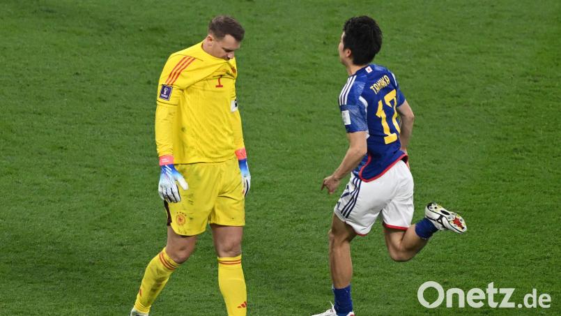 Manuel Neuer (links) schleicht bedröppelt vom Platz, ein Japaner stürmt auf die Jubeltraube zu. Die deutsche Elf verlor überraschend gegen die Asiaten. Bild: Robert Michael/dpa