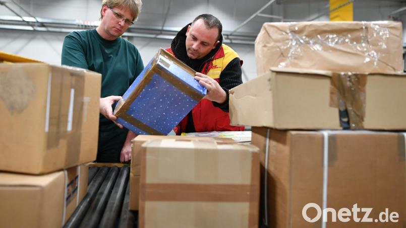 Mitarbeiter des Zolls und der Deutschen Post kontrollieren Pakete in einer Zollabfertigungsstelle. Symbolbild: Uwe Anspach/dpa