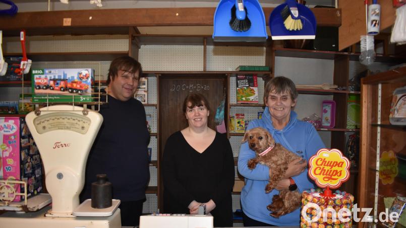 Hinter der Theke vom ehemaligen "Stich" in Bärnau werden ab Freitag (von links) Alexander Fuchs, seine Frau Isabell und seine Schwiegermutter Rita Tschöpel stehen. Zum Inventar gehört auch Hündin Paula. Das Geschäft am Marktplatz heißt künftig "Altstadt-Kramer". Bild: lue