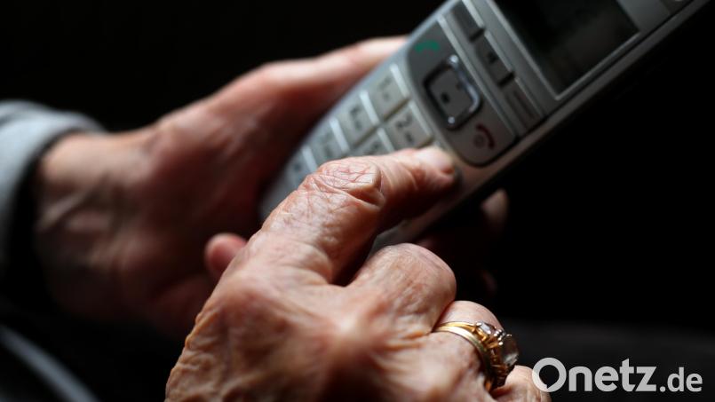 Eine ältere Frau hält ein schnurloses Telefon in der Hand. Am Donnerstag bekam ein Senioren-Ehepaar in Bamberg einen Schockanruf. Symbolbild: Karl-Josef Hildenbrand/dpa