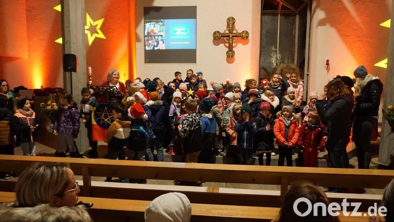 Heidi Dolles-Birner (links am Ambo) mit den Kinder am Ende des adventlichen Nachmittags, der mit Märchen, Musik und Gesang den Alltag vergessen und für die Stiftung &quot;Menschen für Menschen&quot; die Spendenkörbe voll werden ließ. Bild: wec