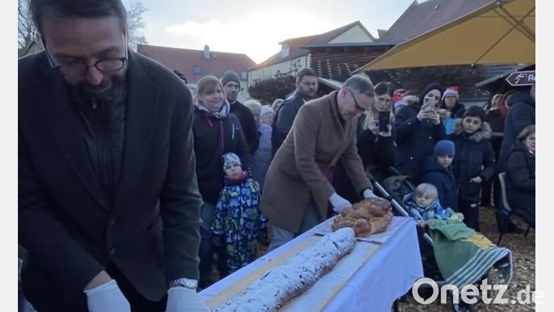 Beim Weihnachtsmarkt schnitten die beiden Bürgermeister Patrik Pitzinger (links) und Bernd Sommer die beiden Stollen an; die Stücke wurden wenig später an die Gäste aus der Partnerstadt und an die Besucher aus Waldsassen verteilt. Bild: Stadt Waldsassen/exb
