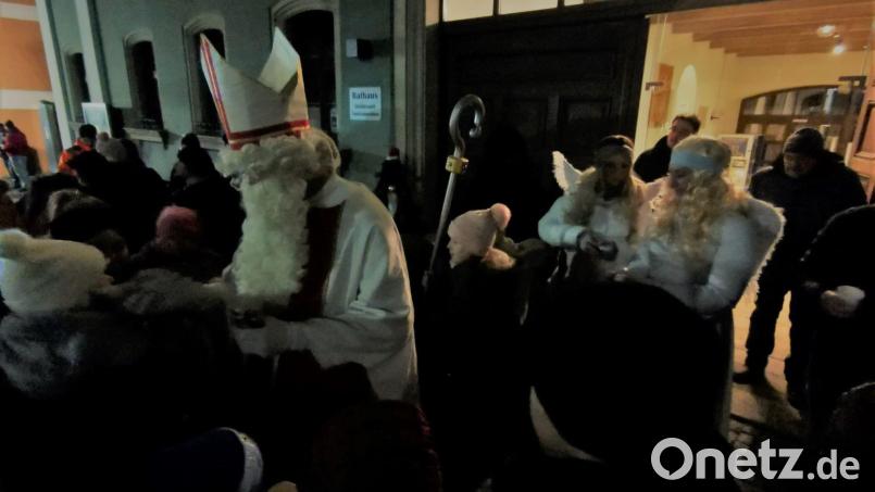 Der Nikolaus verteilt mit den Engeln vor dem Rathaus Geschenke. Bild: gz