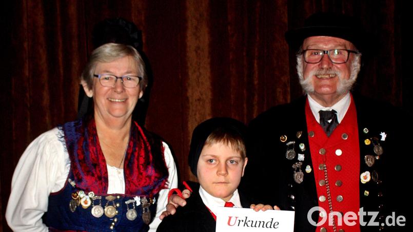 Fünf Jahre ist Luis Ganserer (Mitte) in der Jugendtanzgruppe &quot;d’Altbairischen&quot; dabei. Dafür wird er mit einer Urkunde und einem Geschenk von Christa Binner und Wilhelm Binner geehrt. Bild: R. Kreuzer