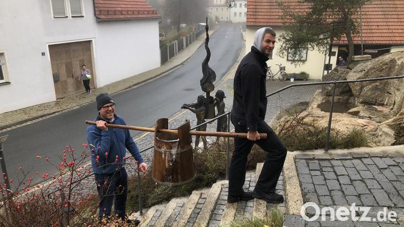 Das Abtragen kann man nur noch in Falkenberg erleben. Im Vordergrund tragen Martin Lauterbach aus Tirschenreuth und Florian Hauner aus Schierling, ein Freund der Familie Gibhardt, die Würze in den Gärraum von Hausbrauer Johannes Bauernfeind. Dahinter ist der neue Zoiglbrunnen, der seit kurzem diesen Brauch am Marktplatz symbolisiert, zu sehen. Bild: wro