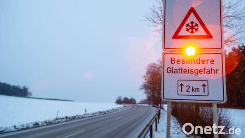 Ein Straßenschild warnt mit einer Blinkleuchte vor Glatteis. Bild: Stefan Puchner/dpa/Symbolbild