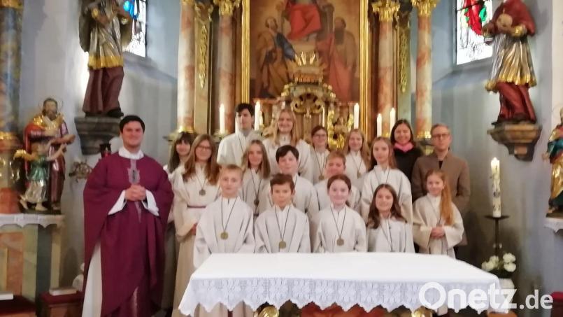 Kaplan Matthias Strätz (links) begrüßt die neuen Ministranten Florian Tröster, Johannes Liegl, Sophie Meiler und Emma Reinwald und verabschiedet langjährige Messdiener, darunter Annemarie Englisch und Andreas Schwarz (rechts). Bild: exb