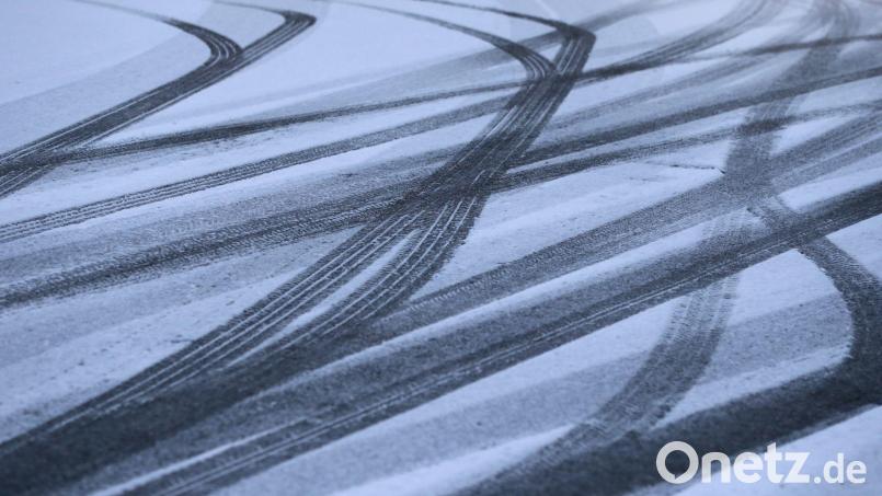 Reifenspuren zeichnen sich auf einer Straße im Schnee ab. Bild: Karl-Josef Hildenbrand/dpa/Symbolbild