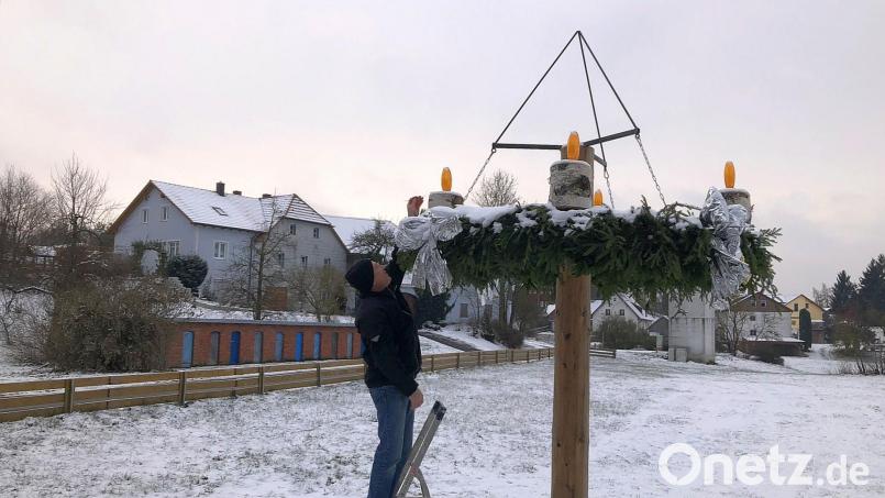 Ab und zu prüft Martin Hecht am großen Adventskranz am Dorfplatz die Funktionsfähigkeit der Dämmerungsschalter, die für das automatische Aktivieren der elektrischen Adventskerzen sorgen. Bild: wro