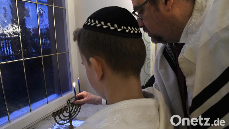Bei der Chanukka-Feier der jüdischen Gemeinde entzündet Rabbiner Elias Dray mit einem Buben in der Synagoge in Amberg eine Kerze am achtarmigen Chanukka-Leuchter. Archivbild: Petra Hartl