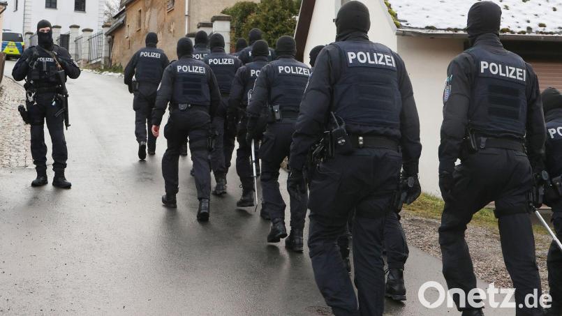 Einsatzkräfte der Polizei laufen während einer Durchsuchung zum Jagdschloss Waidmannsheil. Bild: Bodo Schackow/dpa/Archivbild