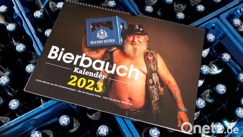 Der &quot;Bierbauchkalender 2023&quot; liegt auf Bierkästen. Bild: Daniel Vogl/dpa/Archivbild