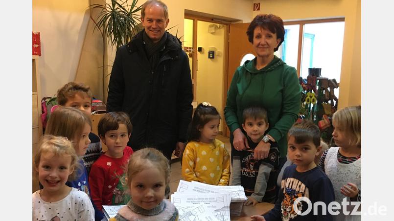 Bürgermeister Kiener überreicht die Malbücher. Bild: Rosenberg/exb