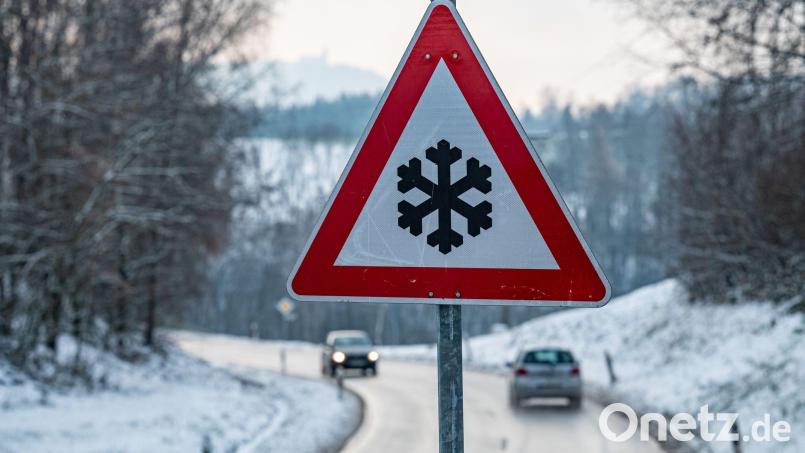 Ein Verkehrsschild, das vor glatter Fahrbahn warnt, steht am Straßenrand. Bild: Armin Weigel/dpa