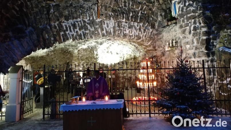 Trotz klirrender Kälte waren zum adventlichen Gottesdienst an der Lourdesgrotte viele Besucher gekommen. Bei der Feier, zu der traditionell die Kolpingsfamilie einlädt, hatte sich die Stadtkapelle im Inneren des Gebetsorts postiert. Bild: Werner Hahn/exb
