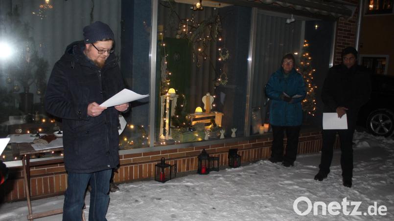 Sprecher des Pfarrgemeinderats Sebastian Wolf (links) sprach bei der Öffnung des Adventsfensters in Ebnath besinnliche Texte. Bild: soj